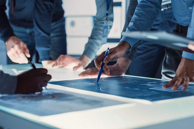 Personas mirando planos sobre ingeniería e infraestrcturas